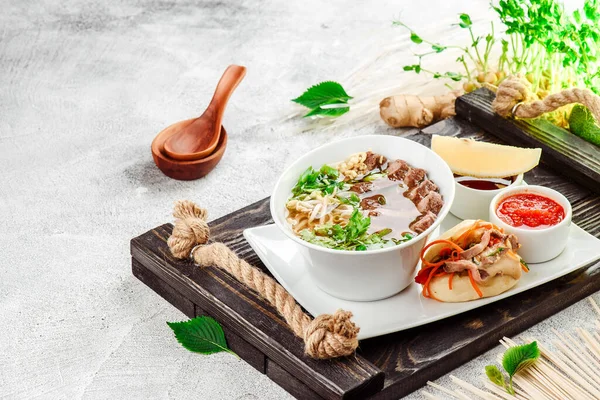 Asiatische Nudelsuppe. Ramen mit Rindfleisch, Tofu und Gemüse auf weißem Teller auf Betongrund. Aus nächster Nähe. Raum für Text — Stockfoto