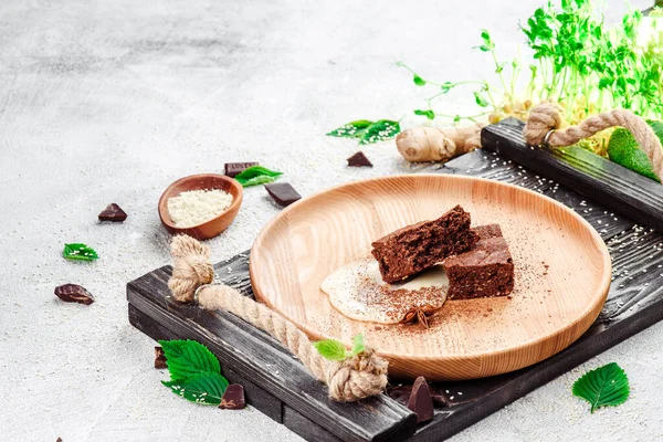 Postre tradicional. Brownie de chocolate en un plato de madera sobre un fondo de hormigón ligero. Espacio para el texto. Primer plano — Foto de Stock