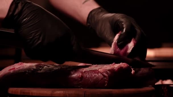 El chef está cortando lomo de ternera crudo en una tabla de madera. Carne de mármol. Ambiente oscuro — Vídeos de Stock