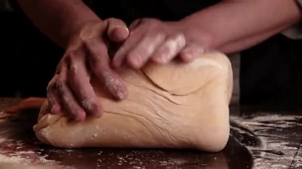 Padeiro chef amassar massa farinhada para pão na padaria caseira. Atmosfera escura. Espaço para texto. — Vídeo de Stock