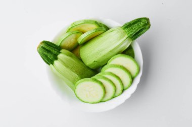 Beyaz arka planda beyaz bir tabakta dilimlenmiş kabak. Modelleme. Kupür için fotoğraf. Yakın plan.