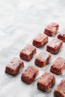 Hafif bir arka planda ham kare pirzola ile kompozisyon. Doğal köpek maması. BARF için diyet