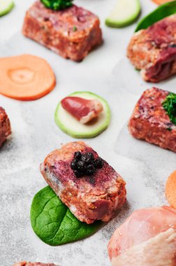 Açık arkaplanda ham kare pirzola ile kompozisyon. Köpekler için doğal yiyecek. BARF köpek diyeti