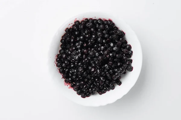 Bilberry on white plate isolated on white background. Top view. Free space for your text. Mockup — Stock Photo, Image