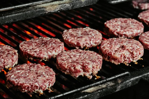 Nyers burger szeletek - organikus marhahúsból készült szeletek grillen. nyers szeletek. közelről — Stock Fotó