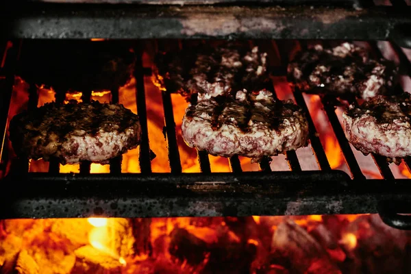 Burger szeletek egy grill - szeletek készült organikus marhahús. nyers szeletek. közelről — Stock Fotó