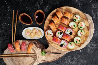 Suşi hazır, rulo Philadelphia, avokadoyla yuvarlan ve ton balıklı yuvarlak ahşap tahta üzerinde yuvarlan. Üst görünüm