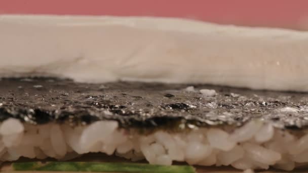 Sushi mestre faz rolos com enguia. O chef coloca enguia frita no arroz com nori. Processo de preparação de sushi. Fechar — Vídeo de Stock