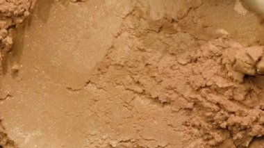 Gerçek altın tozu. Altın tozu okşayan kaşık dokuyu gösteriyor. Doğal kozmetikler. Kapat.