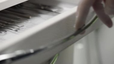 Dişçi diş aletlerinin olduğu çekmeceyi açar. Diş aletleri kapanıyor. Modern ortodonti