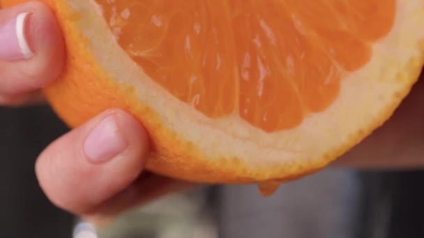 Squeeze orange juice. sliced orange fruit with drops of juice falling from it in slow motion. Close Up macro shot. Fresh fruit — Stock Video