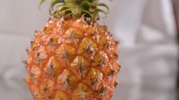 Honigtropfen fallen wunderschön auf Ananas, aus nächster Nähe. Honig fließt auf eine Frucht herab. — Stockvideo