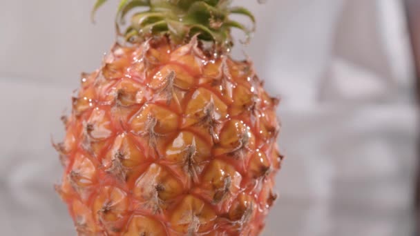 Drops of honey fall beautifully on pineapple, close-up. honey flows down on a fruit — Stock Video