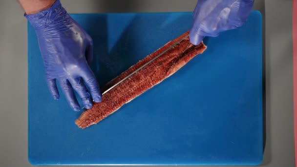 Chef découpe l'anguille frite sur la vue de dessus du plateau bleu. Processus de fabrication des sushis. Gros plan — Video