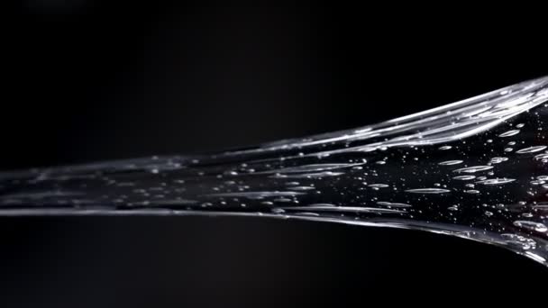 Clear glucose. viscous glucose pours beautifully on a black background. slow motion. — Stock Video