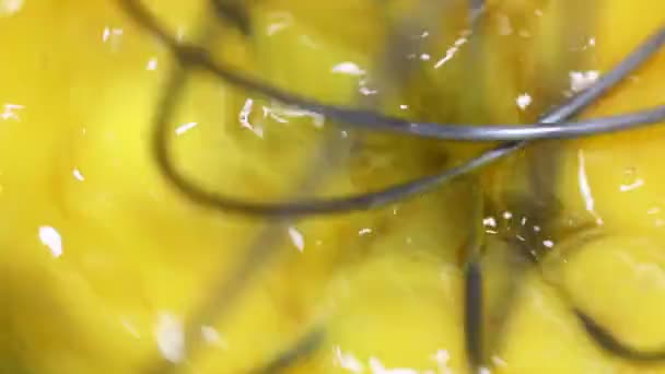 Menger slaat eieren in een tinnen kom. Zweepslagen met dooiers. Bakkerij gebak, close-up. — Stockvideo