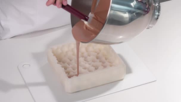 Pastelero vierte la crema marrón en un molde de pastel de silicona. Cocinar un postre de mousse. — Vídeos de Stock