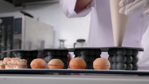 패스 트리 셰프는 크림을 실리콘 케이크 틀에 붓습니다. 무스 디저트를 요리하는 모습. — 비디오