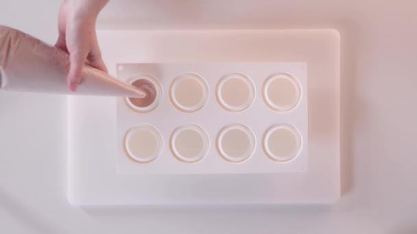 El chef de pastelería vierte la crema de mousse en una sartén de pastel de silicona. Cocinar un postre de mousse. Vista superior — Vídeos de Stock