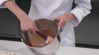 Pasta şefi pasta için çikolatalı mus yoğurur. Tatlıları yapma süreci. Yakın plan..