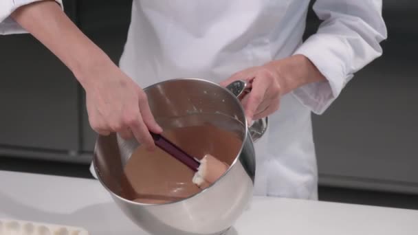 Konditor knådar chokladmoussen till tårtan. Processen att göra desserter. Närbild. — Stockvideo