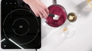 Pasta şefi pasta için pembe krema pişirir. Tatlıları hazırlama süreci. Beyaz masa. Üst görünüm