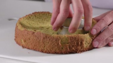 Pasta şefi, metal şekilli bir pasta için bisküvi hamurundan yuvarlak bir şekil kesiyor. Tatlı yapıyorum.