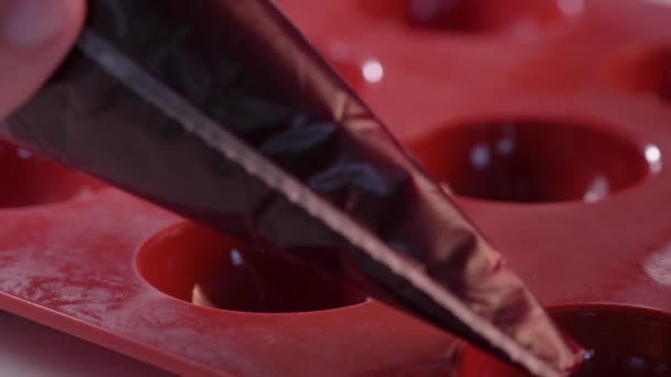 O engarrafamento vermelho aperta de um saco de massa no molde de silicone. processo de fazer um bolo. — Vídeo de Stock