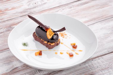 Açık ahşap arka planda beyaz bir tabakta mavi jöleli güzel bir mini kek. Menü ve site için fotoğraf.