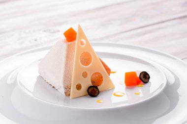 Açık ahşap bir zeminde beyaz bir tabakta piramit şeklinde güzel beyaz bir tatlı. Metin için boşluk