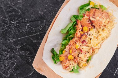 Etten, mısırdan, peynirden ve maruldan oluşan takolardan yapayalnız ve karanlık bir arka planda. Yemeği götür. Menü ve site için fotoğraf