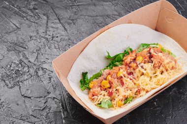 Etten, mısırdan, peynirden ve maruldan oluşan takolardan yapayalnız ve karanlık bir arka planda. Yemeği götür. Menü ve site için fotoğraf