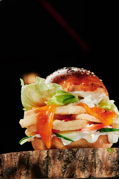 Szaftos burger tintahallal, salátával, sajttal, uborkával és fokhagymás szósszal, fekete háttérrel. Burger menü. A szöveg helye. — Stock Fotó