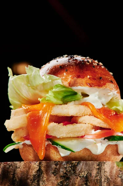 Szaftos burger tintahallal, salátával, sajttal, uborkával és fokhagymás szósszal, fekete háttérrel. Burger menü. A szöveg helye. — Stock Fotó