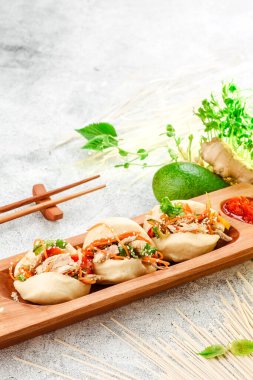 Geleneksel tava yemeği. Bao - etli buğulanmış turta ve Çin yemek çubuklarıyla ahşap tabakta taze sebzeler. Somut bir geçmiş. Metin için boşluk