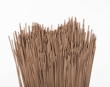 Beyaz arka planda kahverengi spagetti.