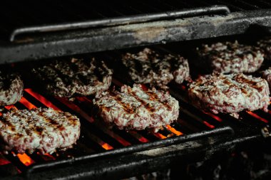 Mangalda hamburgerler, organik biftekten yapılmış pirzolalar. Çiğ pirzola. Kapat.