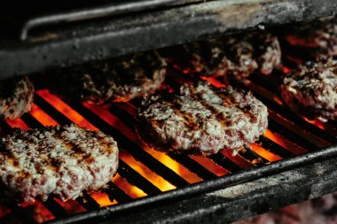 Mangalda hamburgerler, organik biftekten yapılmış pirzolalar. Çiğ pirzola. Kapat.