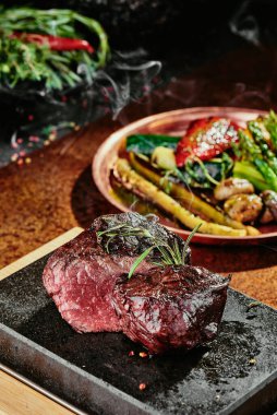 Mayalanmış biftek. Bakır bir çarşafta ızgara sebzeli ızgara biftek. Kapat. seri fotoğraf