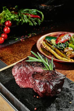 Mayalanmış biftek. Bakır bir çarşafta ızgara sebzeli ızgara biftek. Kapat. seri fotoğraf