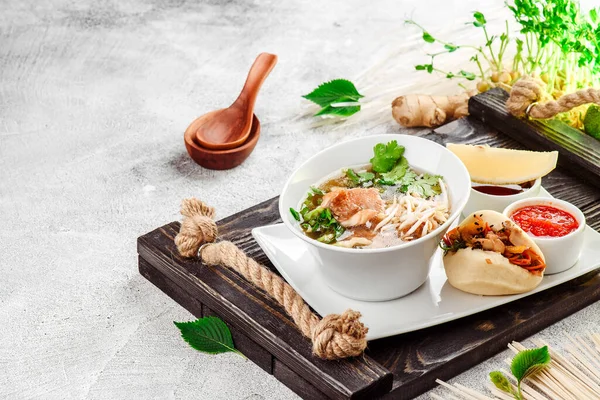 Zuppa di spaghetti asiatici. Ramen con manzo, tofu e verdure in piatto bianco su sfondo di cemento. Chiudete. Spazio per testo — Foto Stock