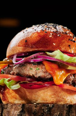 Peynirli sığır burger, domates, kırmızı soğan, salatalık ve marul. Hamburger menüsü. Mesaj için yer var. Sağlıksız yiyecekler.