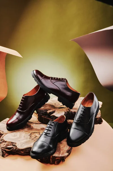 Μαύρα και καφέ δερμάτινα ανδρικά παπούτσια από γνήσιο δέρμα σε κλασικό στυλ σε ξύλινο κόψιμο. Κοντινό πλάνο — Φωτογραφία Αρχείου