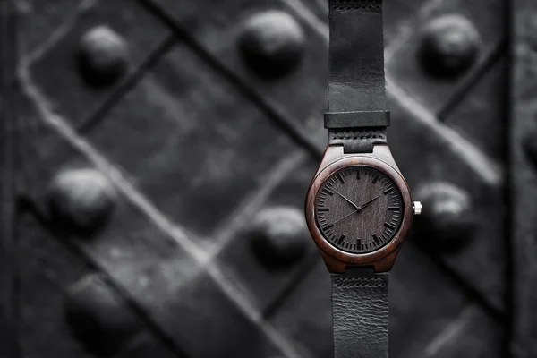 Jam tangan kayu coklat dengan tali kulit pada latar belakang abstrak hitam. Close-up. Ruang untuk teks — Stok Foto