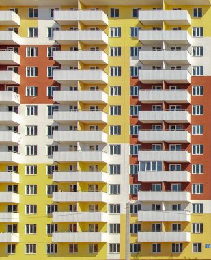 Modern sarı, çok katlı bir bina cephesi. 