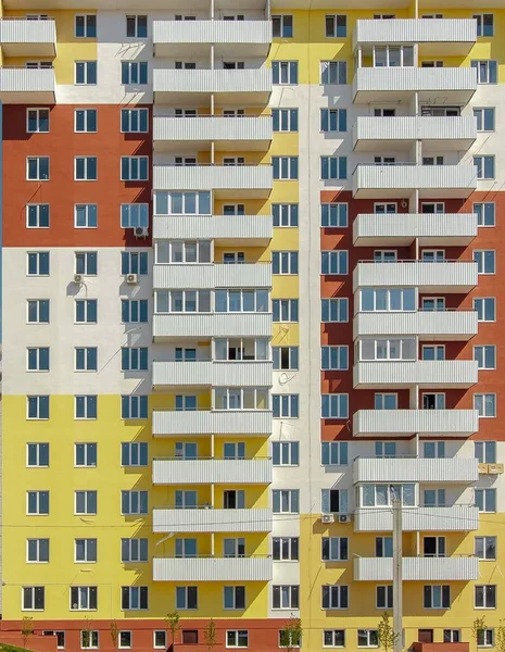 Fachada de un moderno edificio residencial amarillo de varios pisos — Foto de Stock