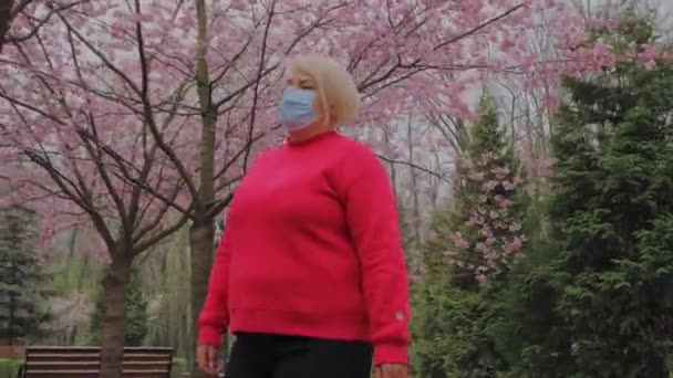 Vitória sobre Covid 19. Mulher europeia tira máscara facial se sente aliviado respiração ar fresco no parque — Vídeo de Stock