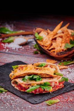 Ahşap arka planda salsa soslu gevrek tacolar. Meksika yemeği ve fast food.