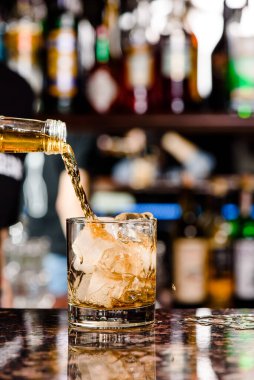 Viski bardağa dökülür. Lokantadaki tezgahta bir bardak viski.