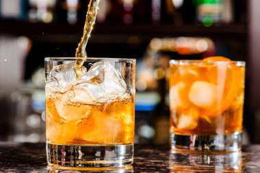 Viski bardağa dökülür. Lokantadaki tezgahta bir bardak viski.